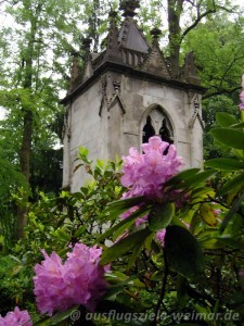 Blühender Rhododendron vor einer Grabkapelle